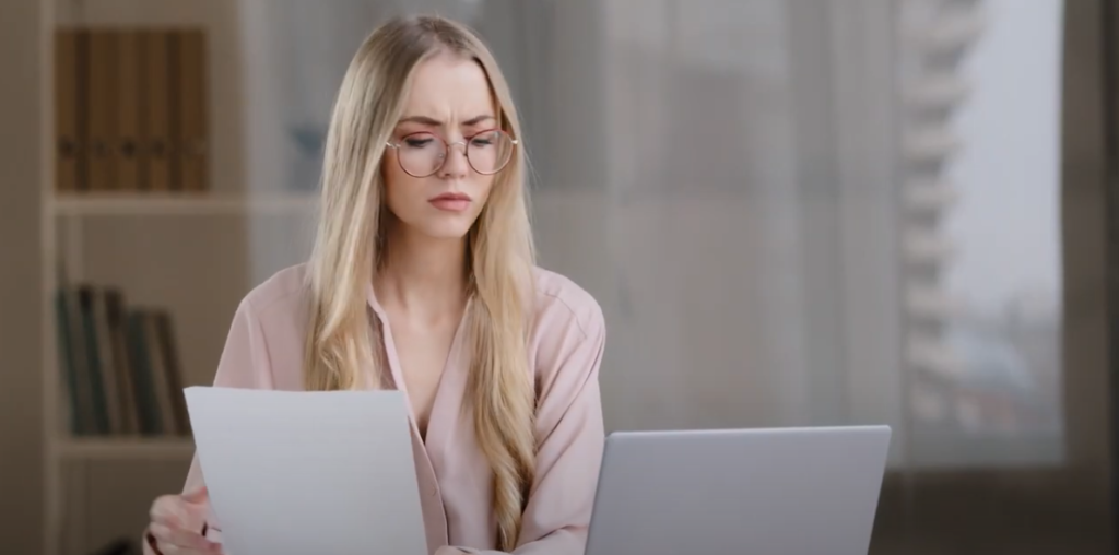 blonde woman with glasses staring at computer